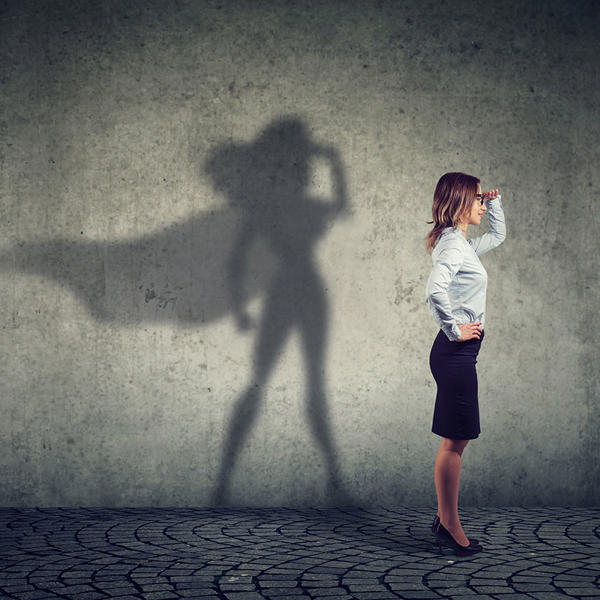 スーパーヒーローの影を見つめる女性