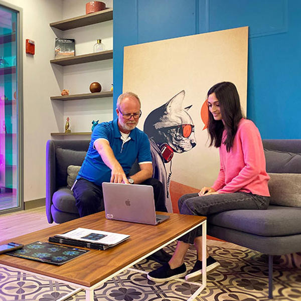 ソファに座ってノートパソコンを見ている男女