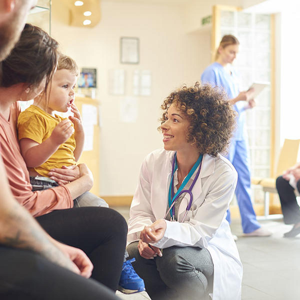 医者と女のいる部屋に座る女と子供