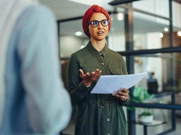 一枚の紙を持つ緑色のドレスを着た女性