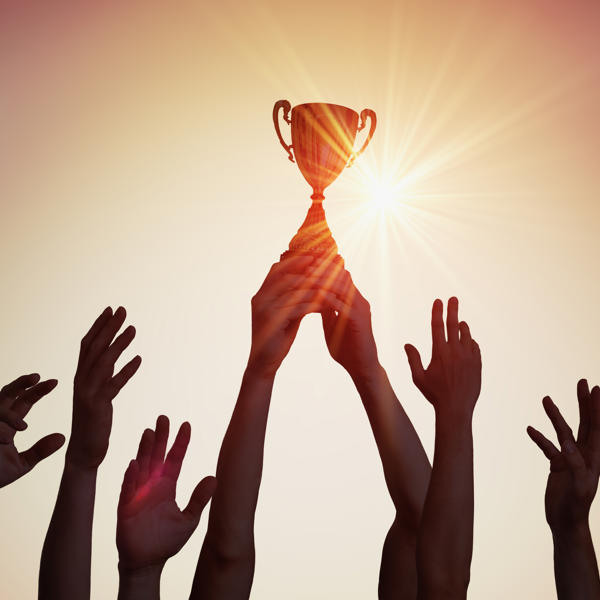 トロフィーに手を伸ばす手のグループ