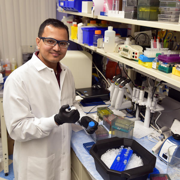 a man in a lab coat holding a test tube
